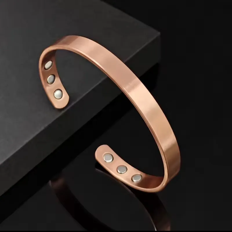 Smooth copper cuff on a dark surface